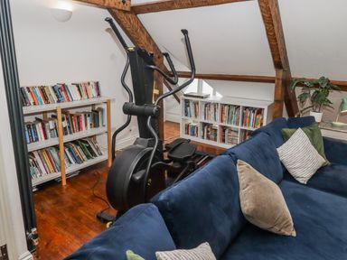 A study with an elliptical machine and bookshelves at The Secret Garden in Narberth