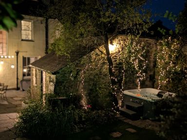 A garden with a hot tub and stone wall at The Secret Garden in Narberth