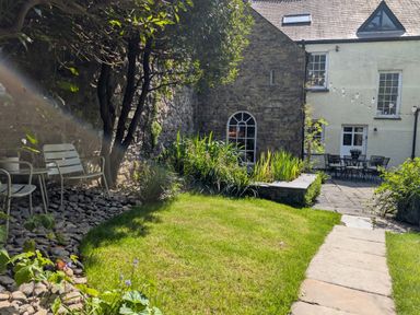 A garden with chairs and a pathway at The Secret Garden in Narberth