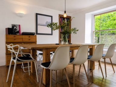 A dining room with a wooden table and chairs at The Secret Garden in Narberth