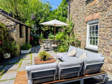 A garden with outdoor furniture and a stone pathway at The Secret Garden in Narberth