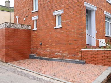 An outdoor area with a brick wall and a door at 16 Elmbank Gardens Paignton