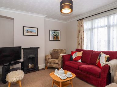 A living room with a television and sofa at 16 Elmbank Gardens in Paignton