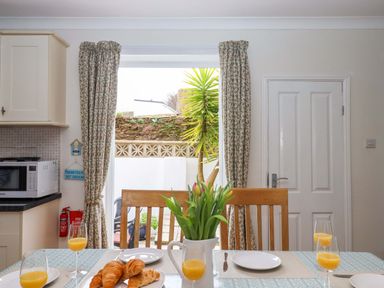 A kitchen with a table and chairs, and orange juice on the table at 16 Elmbank Gardens Paignton