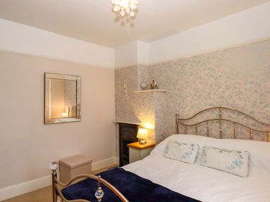A bedroom with a bed and mirror at 16 Elmbank Gardens in Paignton