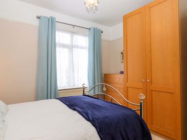 A bedroom with a bed and wardrobe at 16 Elmbank Gardens Paignton