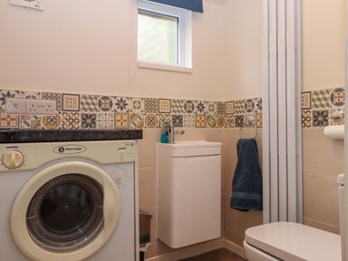 A bathroom with a washing machine and a sink at 16 Elmbank Gardens Paignton