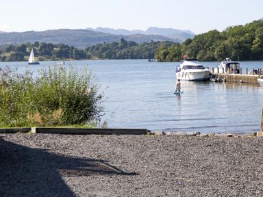 A lake with boats and a person on a paddleboard at Waters Edge Lodge in Windermere
