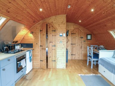 A kitchen with cabinets and dining area at Vine View near Halesworth