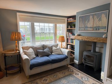 A living room with a sofa and fireplace at York Cottage in Southwold