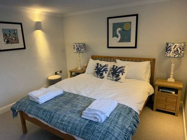 A bedroom with a bed and bedside lamps at York Cottage in Southwold