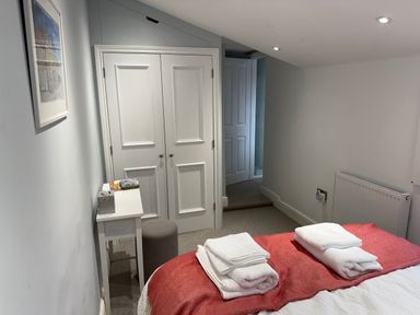 A bedroom with a bed and towels at York Cottage Southwold