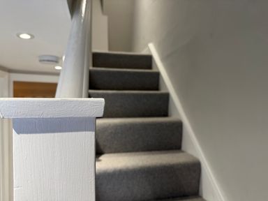 A staircase with a carpet and handrail at York Cottage Southwold