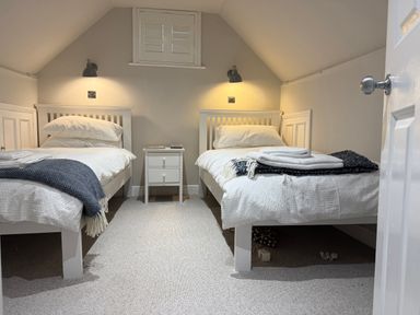 A bedroom with two beds and a nightstand at York Cottage Southwold