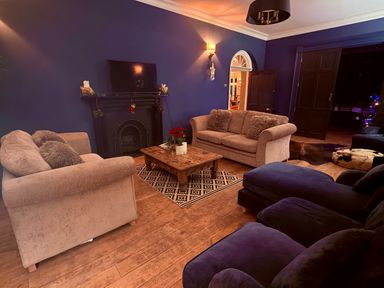 A living room with a television and fireplace at Picton House near St Clears