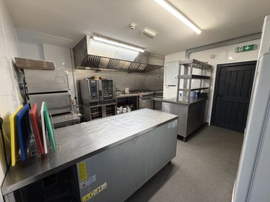 A commercial kitchen with stainless steel appliances at Picton House near St Clears