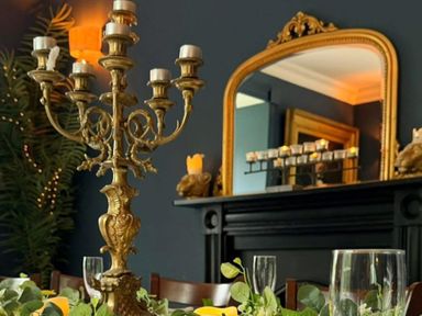 A dining room with a candelabra and a mirror at Picton House near St Clears