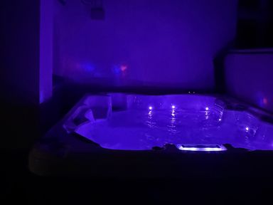 A hot tub with LED lights in an indoor bathroom at Picton House near St Clears
