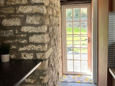 A kitchen with a door opening to the outside at Coach House near St Clears