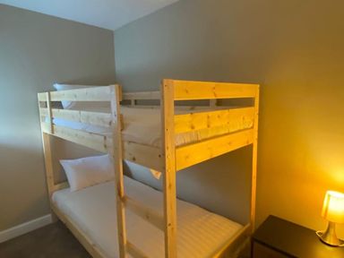 A bedroom with a bunk bed and nightstand at Coach House near St Clears