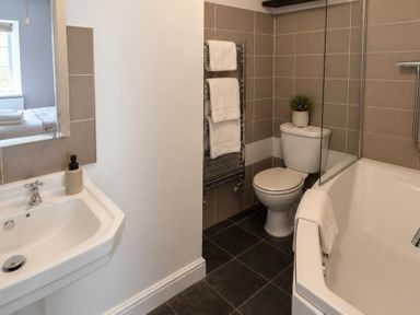 A bathroom with a sink, bathtub, and toilet at Coach House in St Clears