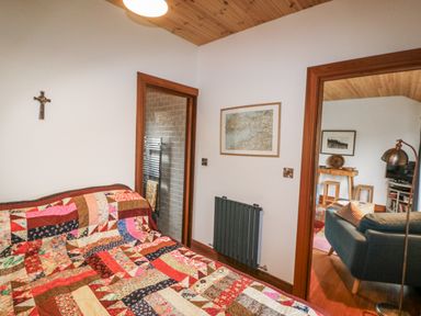 A bedroom with a bed and doorways at The Faithfuls Cabin in Dingle