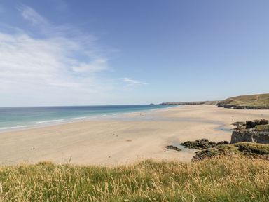 A beach with sand and ocean at Barney's Retreat in Newquay