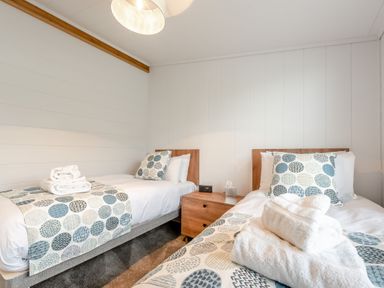 A bedroom with two beds and towels on top at Sonnet 3 Spa in Carmarthen