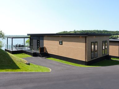 A house with a deck and outdoor furniture at Wilde Spa in Carmarthen