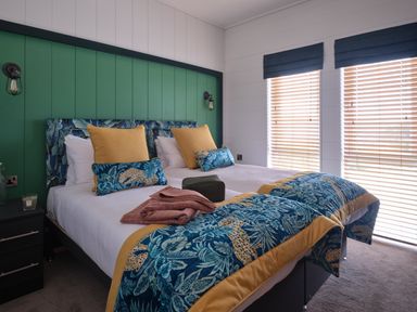 A bedroom with two beds and decorative pillows at Wilde Spa in Carmarthen