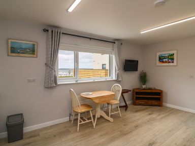 A dining room with a table and chairs at Radharc an Hook @ Estuary Bliss
