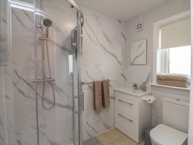 A bathroom with shower, sink, toilet, and towels at Radharc an Hook @ Estuary Bliss