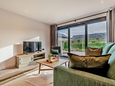 A living room with a television and sofa at Arvor Studio 1.0 in Bude