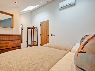 A bedroom with two beds and a mirror at Whalesborough Penthouse 2.0 Marhamchurch
