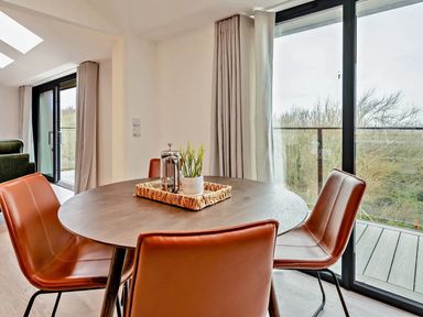 A dining room with a round table and chairs at Whalesborough Penthouse 2.0 in Marhamchurch