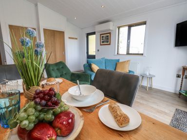 A dining room with a table set and living area in view at Grass Roots