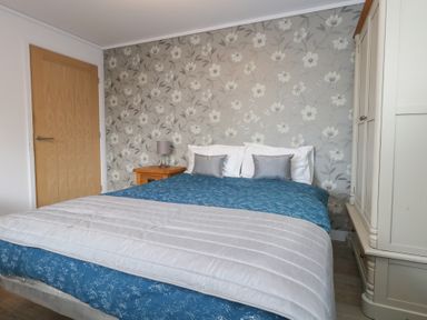 A bedroom with a bed and nightstand at Grass Roots