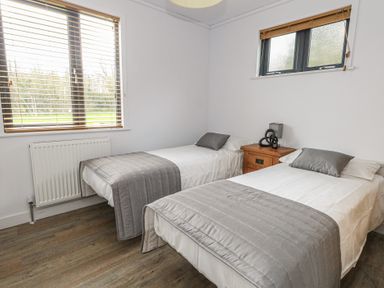A bedroom with two beds and a bedside table at Grass Roots