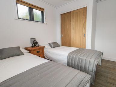 A bedroom with two beds and a bedside table at Grass Roots