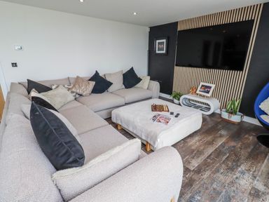 A living room with a sofa and TV at The Joiners Cottage Birling near Warkworth