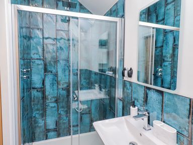 A bathroom with shower and sink at The Joiners Cottage in Birling near Warkworth
