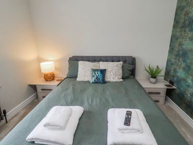 A bedroom with a bed and lamp at The Joiners Cottage in Birling near Warkworth