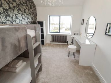 A bedroom with a bunk bed and desk at The Joiners Cottage in Birling near Warkworth