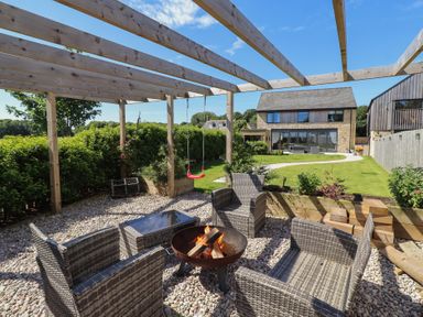 A garden with seating and a fire pit at The Joiners Cottage in Birling near Warkworth