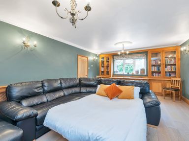 A living room with a large sofa and bookshelf at Oldfields
