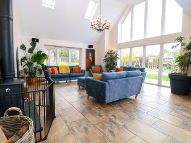 A living room with sofas and plants at Oldfields in Bury St Edmunds