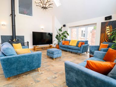 A living room with sofas and a television at Oldfields Bury St Edmunds