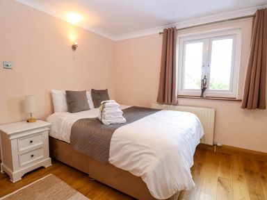 A bedroom with a bed and bedside table at Oldfields in Bury St Edmunds