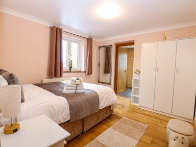 A bedroom with a bed and wardrobe at Oldfields in Bury St Edmunds