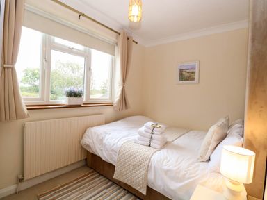 A bedroom with a bed and window at Oldfields in Bury St Edmunds